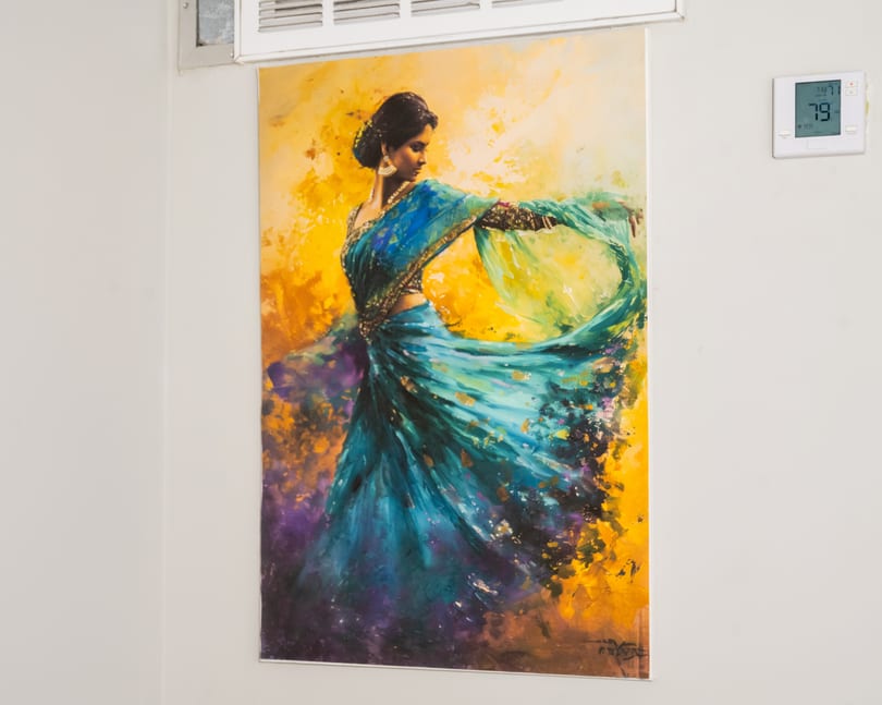 Vibrant painting of a woman in a flowing blue and green sari against a yellow and purple background.
